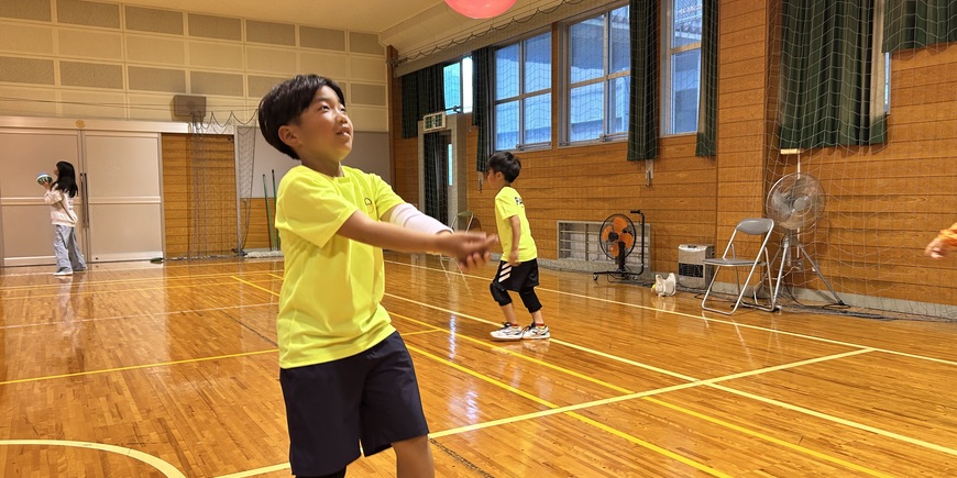 体育館でバレーボールを楽しむ小学生